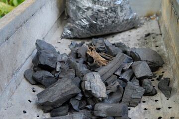 Pile of Black Charcoal Lumps in a Metal Grill Tray
