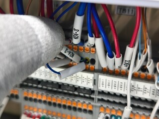 Close-up Electrical Wiring Installation in Control Panel, Hand in Glove