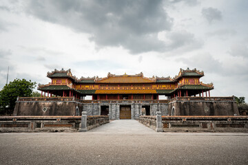 Fototapeta premium Majestic Imperial Gate of the Citadel in Hue, Vietnam, under a dramatic cloudy sky, showcasing ancient Asian architecture and rich cultural heritage.