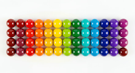 Fototapeta premium Bright, rainbow-colored plastic beads arranged in a fun pattern, like sweet sugar candy spheres on a white background
