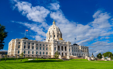 Minnesota State Capitol building stands in Saint Paul, USA. Renaissance Revival architecture features a white marble dome and golden quadriga statue under a blue sky