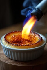 Close-up of a dessert with caramelized sugar being torched with a blue flame, capturing the caramelization process and texture on the surface