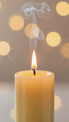 Candle burning with smoke against a blurred bokeh background  