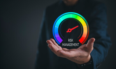 Businessman hand holding virtual risk management gauge. Concept of business strategy, financial assessment, safety control analysis, market volatility evaluation and corporate crisis protection plan.