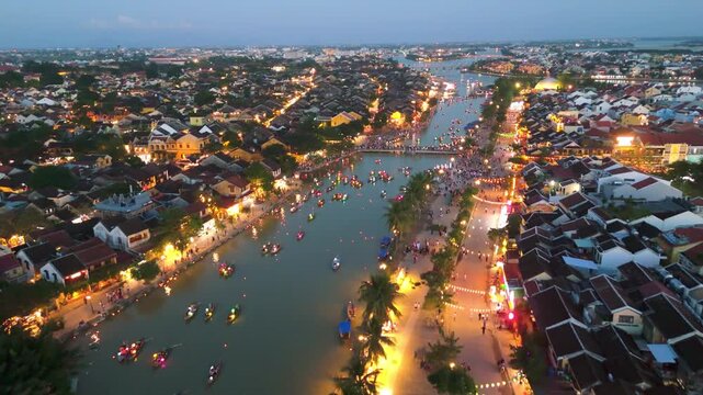 aerial drone of Hoi An Ancient Town, Vietnam, during sunset Traditional colorful lanterns illuminate the Thu Bon River and historic houses, highlighting the UNESCO World Heritage site