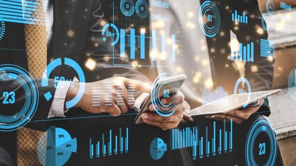 Two business professionals review data on a smartphone and tablet, surrounded by digital graphs and charts. The scene reflects modern analytics and technology in a corporate setting. Xenic - Powered by Adobe