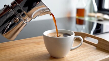 Pouring Freshly Brewed Coffee From A Moka Pot Into A White Cup.