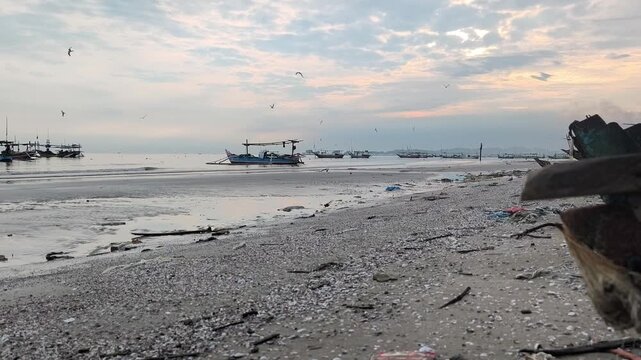The atmosphere of Tuban beach, East Java, Indonesia in the morning with fishing boats anchored, with calm sea waves