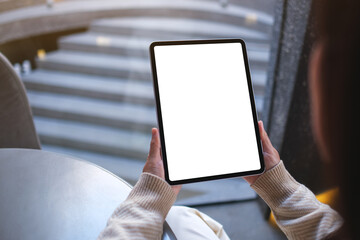 Mockup image of a woman holding digital tablet with blank white desktop screen in cafe