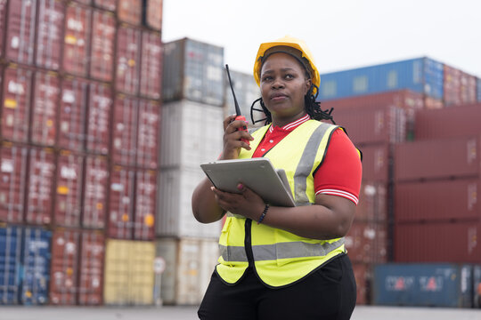 Cargo container and Import, export , African American worker inspecting and control of cargo container. Female worker working and managing container at container yard
