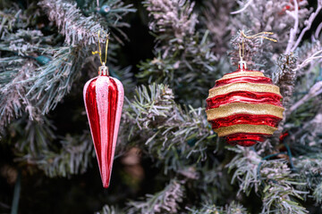 Close-up of a beautifully decorated ornament hanging on a artificial Christmas tree.