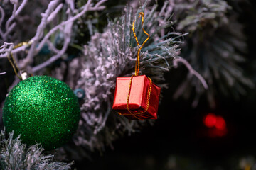 Close-up of a beautifully decorated ornament hanging on a artificial Christmas tree.