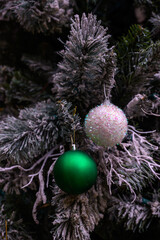 Close-up of a beautifully decorated ornament hanging on a artificial Christmas tree.