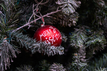 Close-up of a beautifully decorated ornament hanging on a artificial Christmas tree.