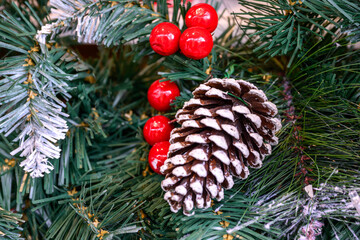 Close-up of a beautifully decorated ornament hanging on a artificial Christmas tree.