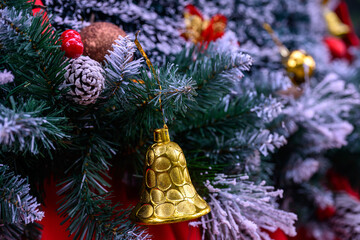 Close-up of a beautifully decorated ornament hanging on a artificial Christmas tree.