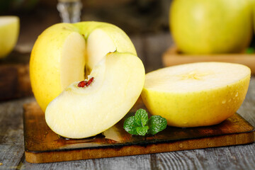 Fresh Yellow Apples Sliced on Wooden Board with Mint