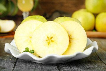 Fresh Yellow Apples Sliced on White Plate with Mint Garnish