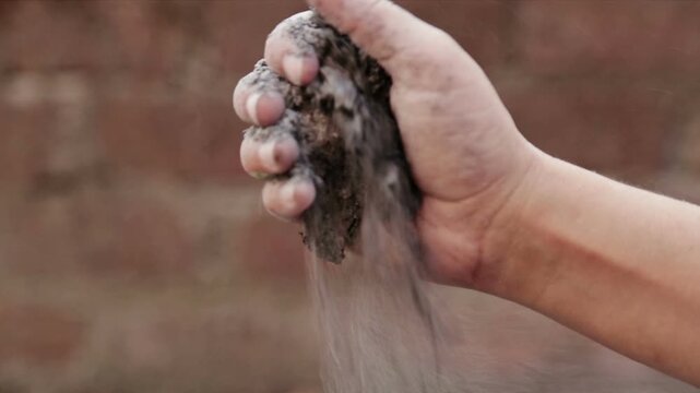 An Indian adult hand holds loose soil outdoors. The image represents earth, sustainability, agriculture, nature connection, and environmental awareness in India.
