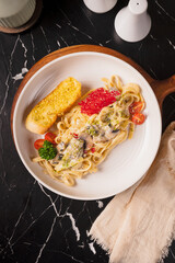 Creamy Mushroom Pasta with Garlic Bread on a Marble Table.