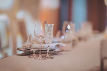 Setting a table with various glassware for a dining event during the evening hours in a well-decorated space