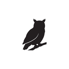 Silhouette of an owl perched on a branch