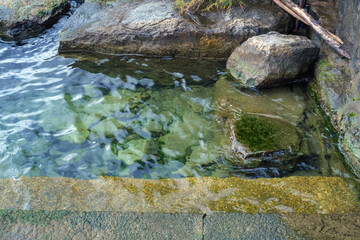 Clear, flowing water over rocks in a natural setting