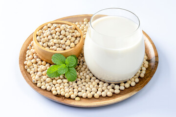 Soy milk in a glass and soybeans on white background