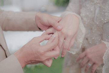 the groom puts the ring on the bride