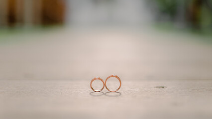 wedding rings on a wooden base with a wedding altar background