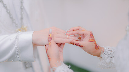 the groom puts the ring on the bride