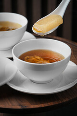 Chinese-style seafood soup, restaurant interior photography with blurred background.