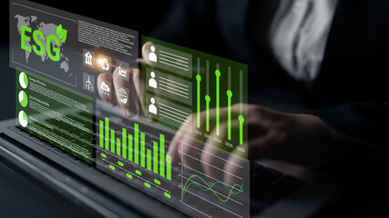 Business professional engages with ESG data on a laptop, showcasing interactive graphs and charts...