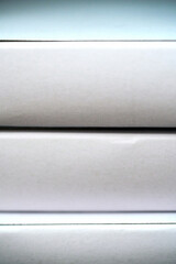 White boxes stacked in a row on a shelf