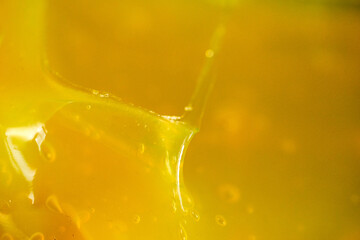 Honey dripping from a spoon in sunlight