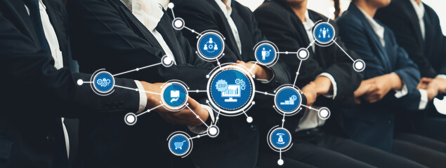 A group of business professionals engaging in a collaborative discussion, surrounded by visual elements representing technology and connectivity in a modern office environment. Amity