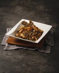 Delicious Asian-inspired dish with chicken and vegetables in a rich sauce, served in a white bowl on a rustic wooden board.