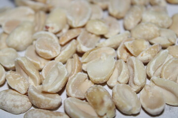 Dried white peanuts displayed on a flat surface in a natural light setting during daytime