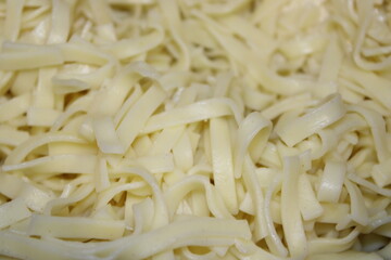 Freshly made pasta is laid out on a wooden surface ready for cooking or serving with various sauces and toppings later