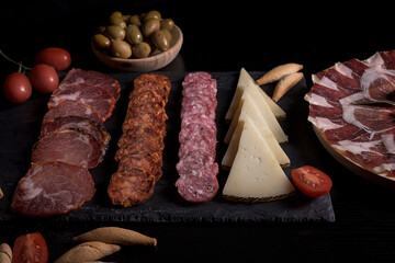 Dark moody charcuterie board with Iberian cured meats ham salami chorizo lomo and cheese