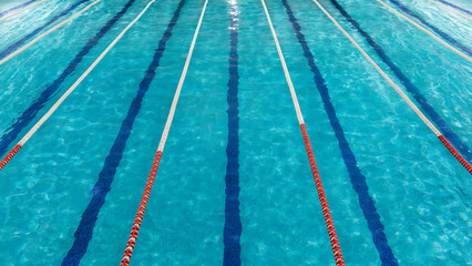 Empty swimming pool lanes with clear blue water, top view background texture
