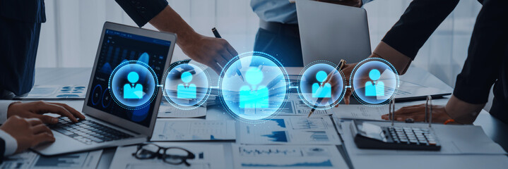 A group of diverse professionals engaged in a collaborative business meeting, utilizing modern technology to analyze data and present innovative ideas in a stylish office setting. Trope