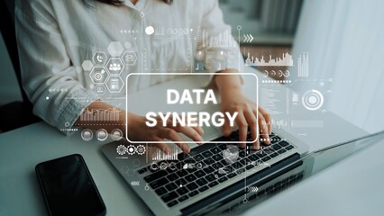 Business professional typing on a laptop with data analytics graphics overlay focused on data synergy and technology integration. Asymptotic smart data analytic.