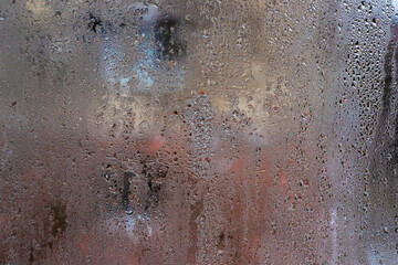 abstract background of wet glass. Condensation on a glass surface creating a colorful and textured background, ideal for adding a soft, atmospheric effect to designs.