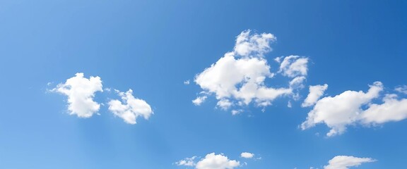 Obraz premium Bright clear blue sky with scattered abstract white clouds on a sunny day, clear sky, open space