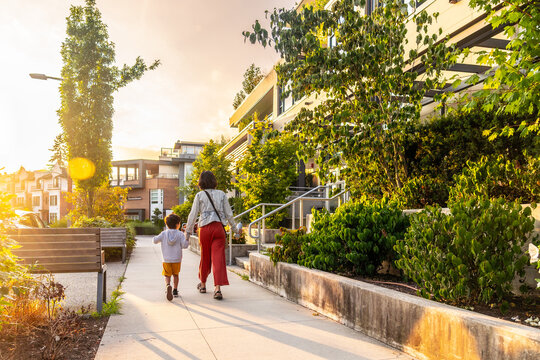Mother and son walking in vancouver residential area at sunset