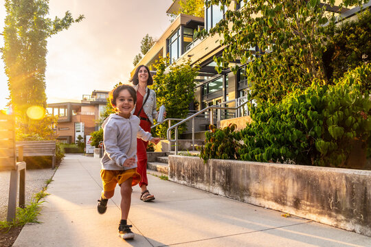 Happy child running in vancouver with mother at sunset