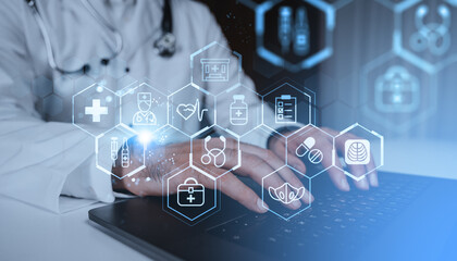 Doctor using laptop with digital medical hologram interface on futuristic blue background, representing healthcare technology concept innovation.