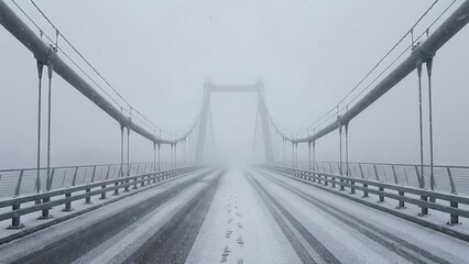Long Suspension Bridge Covered in Fresh Snow and Heavy Fog with Tire Tracks Leading into the Distance, Evoking Winter Travel and Solitude