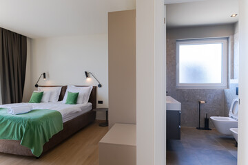  Modern open-plan living and dining room in a luxury villa with large glass doors opening to a private swimming pool, offering a spacious and elegant indoor-outdoor living experience